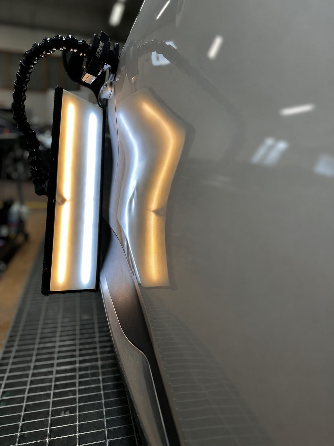Dents on a door revealed by the PDR light tunnel in the workshop